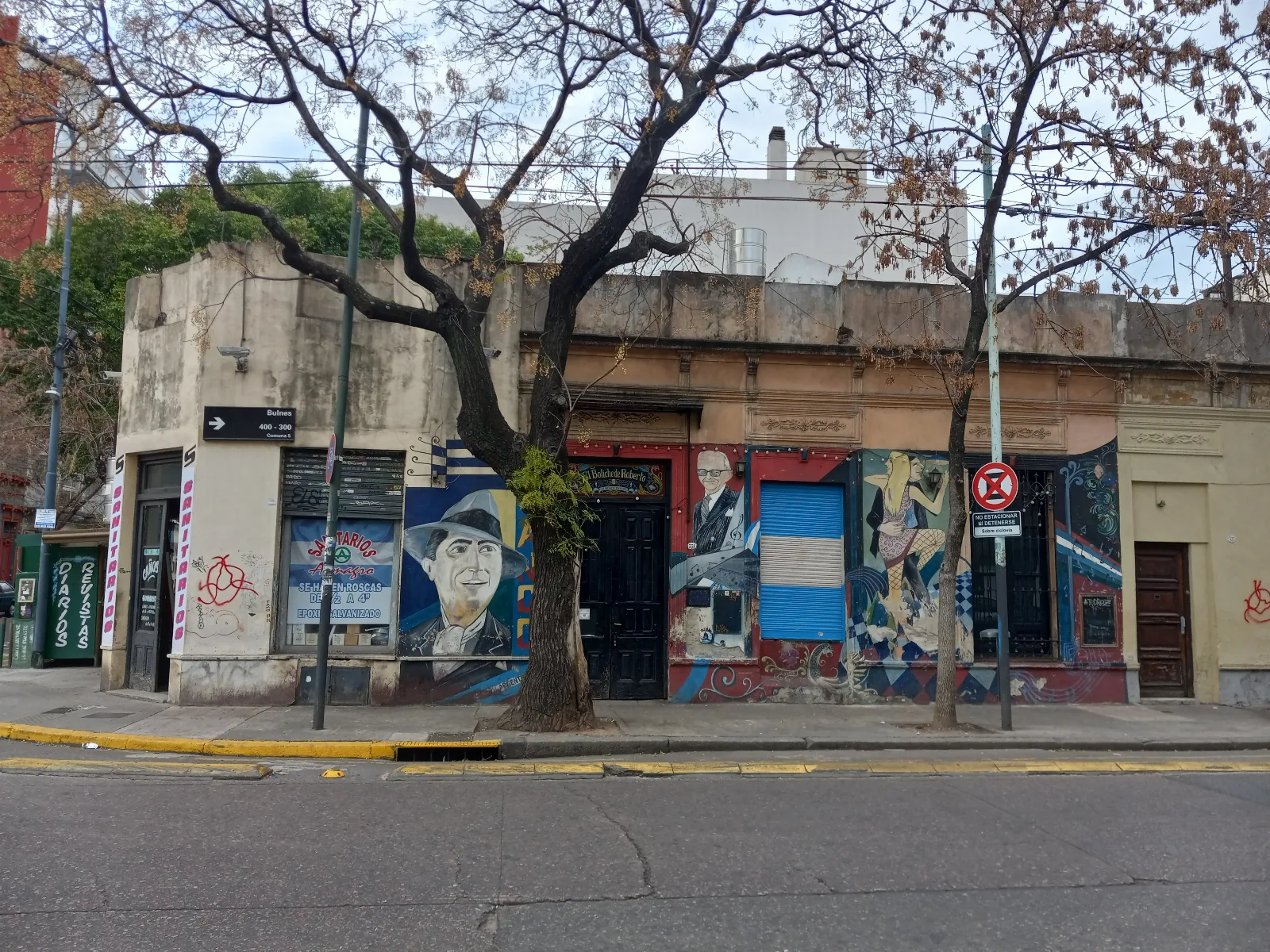 Estudiantes caminando por una avenida de Buenos Aires con edificios universitarios al fondo