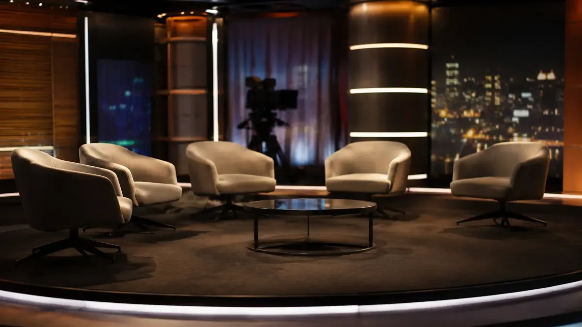 Sillones vacios de un panel de television sobre el set con luces calidas