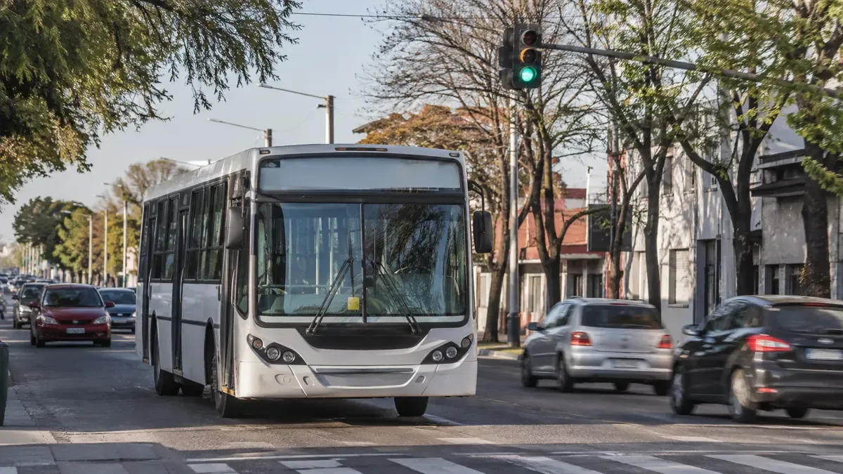 Colectivo urbano circulando por una avenida en hora pico