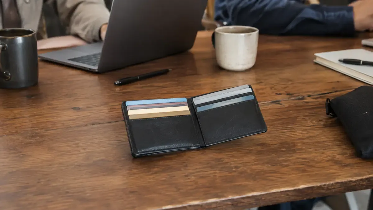 Una billetera abierta con tarjetas completamente genéricas en una mesa compartida de trabajo, plano medio documental, perspectiva natural