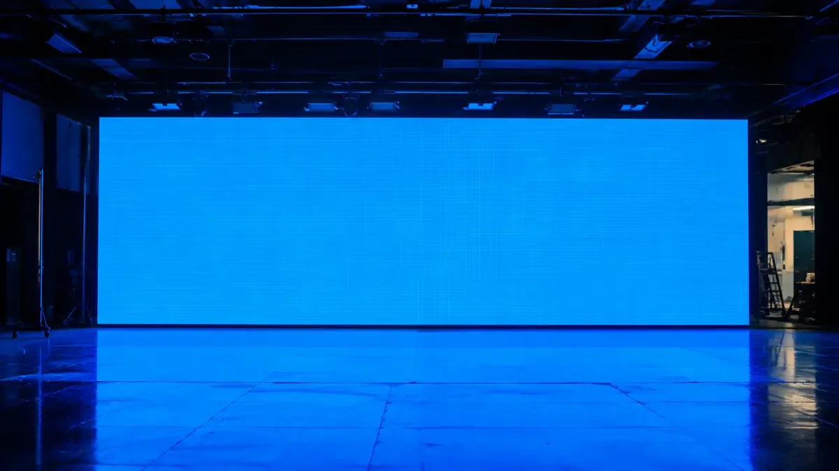 Gran pantalla LED encendida en azul liso como fondo de un set vacio